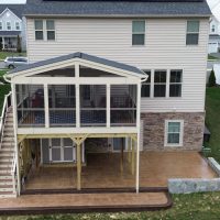Screened porch with gable roof and a stamped concrete patio.